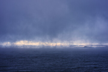 Lake Mjosa with view towards rural Ringsaaker i misty day in December.