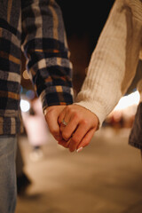 The man and woman holding each other hands with crystal ring 