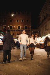 Young couple in love walking at Italian Christmas market in Verona 