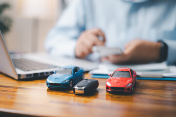 Toy Car In Front Of Businessman Calculating Loan. Saving money for car concept, trade car for cash concept, finance concept. - obrazy, fototapety, plakaty