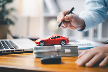 Toy Car In Front Of Businessman Calculating Loan. Saving money for car concept, trade car for cash concept, finance concept.