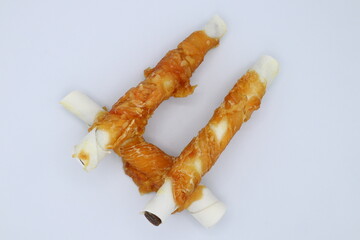 Chew stick dogs. Wrapped in meat. Candy or treat for pets. Close up and isolated.
