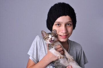 Menino com gatinho doméstico fofo em retrato de estúdio 
