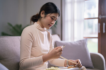 Young asian woman use punch needle and yarn to embroidery craft on fabric frame in hobby lifestyle