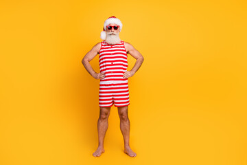 Full length photo of funky confident senior guy dressed christmas swimwear hat dark glasses empty...