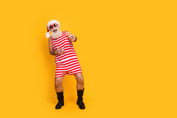 Full length photo of funky positive senior guy dressed christmas swimwear laughing pointing you empty space isolated yellow color background - obrazy, fototapety, plakaty