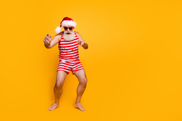 Full length photo of positive crazy elderly guy wear new year swimsuit hat sunglass having fun...
