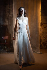 Elegant and beautiful brunette in a chic evening dress or wedding dress, white dress with a long...