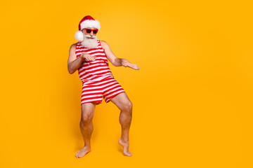 Full length photo of positive cheerful senior guy christmas swimwear hat enjoying discotheque empty...
