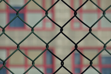 Urban view of a building through a wire mesh in the foreground