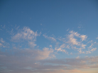 Blue sky after rain,. Beautiful Cumulus clouds flying across the sky, sunset rays, pink shades in the clouds, deep blue sky