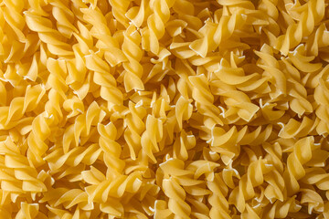 Uncooked Fusilli Pasta: A Culinary Canvas of Spiral Macaroni, Creating a Lively and Textured Background for Gourmet Cooking. Dry Pasta. Raw Macaroni - Top View, Flat Lay