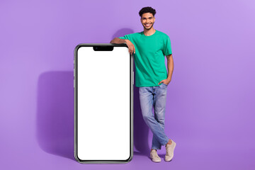 Full length body cadre of young satisfied man confident recommend samsung high quality screen no glares isolated on purple color background