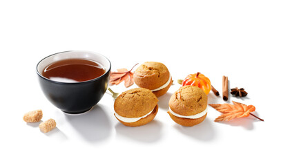 Pumpkin  sandwich cookies with cream cheese filling and cup of tea isolated on white background 