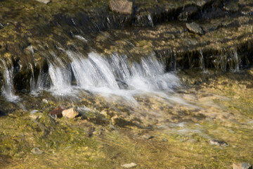 Fototapeta na wymiar Waterfall over natural rocks