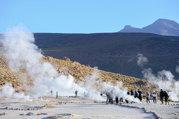 Turistas circulando no Gêiser Tatio no deserto do Atacama durante o começo do dia. Nascer do sol. 