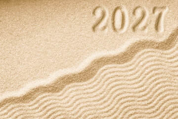 Imprints of numbers 2027 new year on a golden sand waves