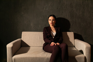 Business woman sitting on couch in office space