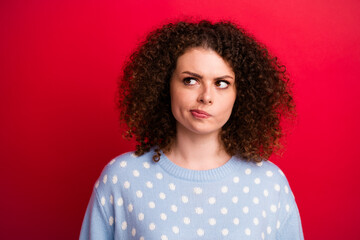 Photo of funny thoughtful girl preparing merry christmas gift and looking novelty choosing package isolated on red color background