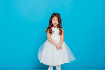 Girl in white elegant dress on a blue background Holiday