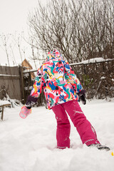 child playing with snow in winter