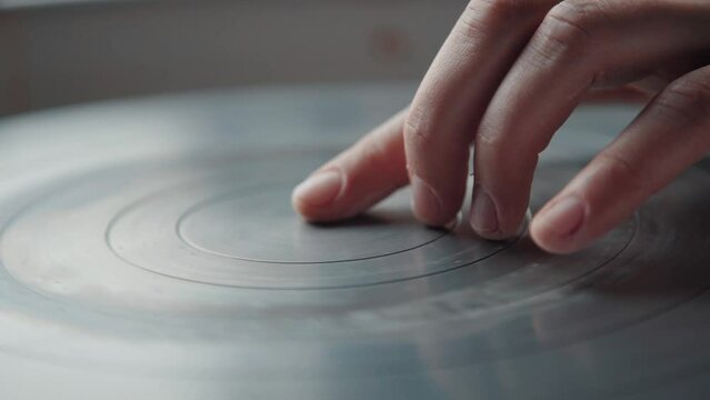 The ceramist stops the potter's wheel with a finger. Tool for the potter in the creative workshop.