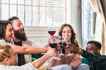 Cheers! People celebrate and raise glasses of red wine for toast.