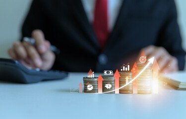 Profitable investment concept, businessman using calculator to calculate returns, stack of coins with gradient from least to highest and arrow going up.