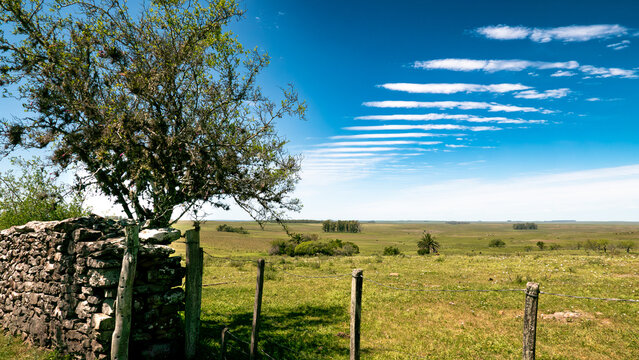 Paisaje rural con extra&ntilde;a formaci&oacute;n de nubes formando l&iacute;neas paralelas