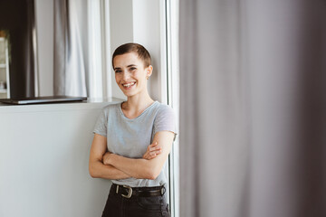 Confident young woman with short hair crossed arms looking at camera