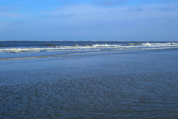 Wellen brechen am Strand der holländischen Nordseeinsel Schiermonnikoog an einem stürmischen Herbsttag.