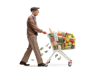 Full length profile shot of a senior man losing money and pushing a shopping cart