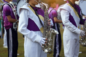 Orchestra students play saxophones in a parade at the school's athletics event. Soft and selective...