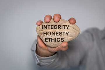 Honesty and integrity symbol. businessman holds in his hand a stone engraved with the...