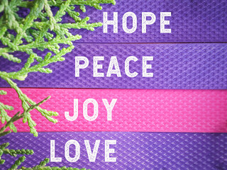 Advent hope peace joy love on purple and pink background. Advent season for Christmas celebration preparation concept. 