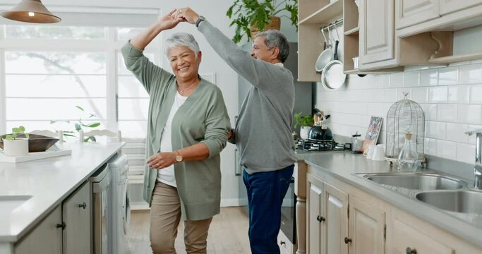 Love, smile and senior couple dance, hug and bond in a kitchen, happy and enjoying romance in their home. Fun, music and elderly man with woman dancing, embrace and sharing romantic moment