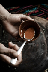 mano de mujer mexicana, salsa roja en bol de arcilla