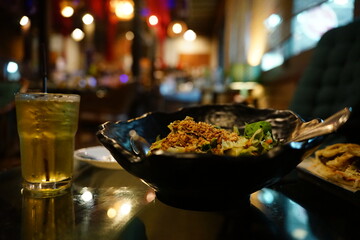A ramen noodle and a chrysanthemum juice in a dark tone restaurant. The background is blurred.