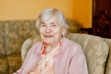 Fototapeta na wymiar Senior woman of 90 years sitting at home. Portrait of old happy retired lady indoors