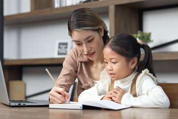 Asian little cute girl learning and studying her lesson with mother at home, schoolgirl pupil does homework with female tutor teacher, happy child student learning writing, homeschool kid education.
