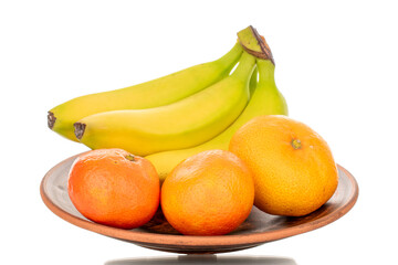 Several ripe bright yellow bananas and tangerines on a clay plate, macro, isolated on white background.