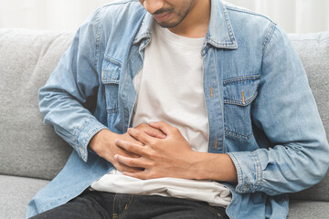 Flatulence ulcer, hurt suffer asian young man, male hand in belly, stomach pain, ache from food...