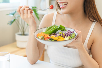 Diet concept, happy asian young woman hand use a fork to prick tomato, fresh vegetable or green...