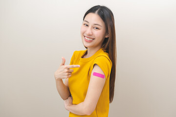 Healthcare of Covid-19, coronavirus vaccination, happy asian young woman hand pointing, showing at bandage, plaster on arm, getting vaccine immunity, giving injection influenza to protection pandemic.