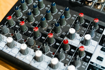 Closeup and detail of audio mixing console with faders and knobs