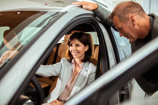 Woman testing vehicle with husband in car dealership