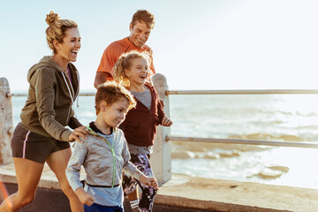 Happy family enjoying a run by the seaside