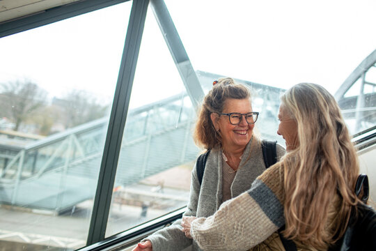 Two happy senior women in train station