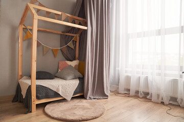 A child's bed made of wood in the shape of a house. The concept of arranging a children's room with...