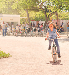 A little Caucasian girl, walking happily with her bicycle in a park